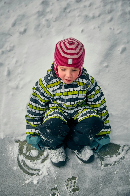 a small child sitting in the snow on a snowboard, by Jaakko Mattila, looking down from above, multicoloured, grey, lined in cotton