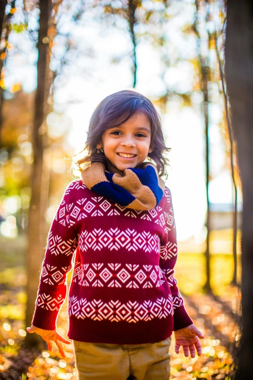 a little girl standing in the middle of a forest, by Lilia Alvarado, shutterstock contest winner, sweater, warm smile, vibrant patterns, boys