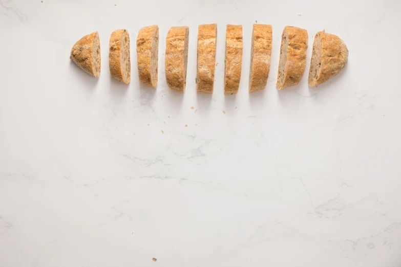 a piece of bread sitting on top of a cutting board, on a large marble wall, dividing it into nine quarters, detailed product image, pointè pose