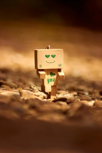 a small piece of wood with a smiley face on it, a picture, unsplash, happening, < full body robot >, i love you, cubic, brown