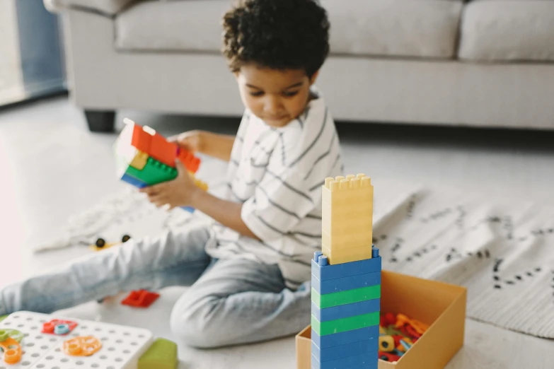 a young boy sitting on the floor playing with blocks, pexels contest winner, toy package, lego style, riyahd cassiem, animation