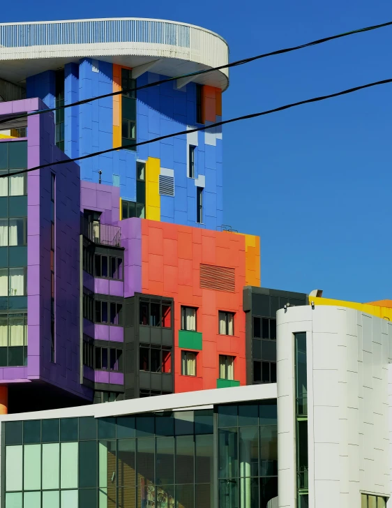 a multicolored building on the corner of a street, a photo, inspired by Mondrian, unsplash, medical complex, frank gehry, melbourne, set photo