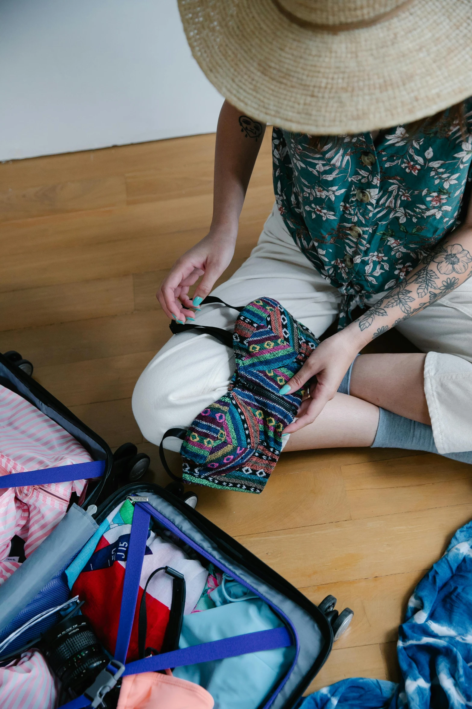 a woman sitting on the floor with a suitcase full of clothes, by Carey Morris, trending on pexels, patterned, blue undergarments, wearing adventure gear, avatar image