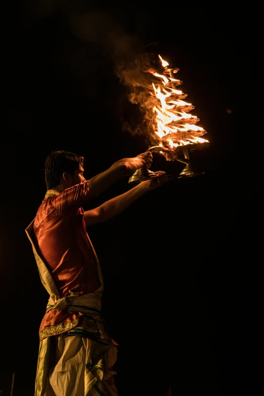 a man with a fire stick in his hand, by Sam Dillemans, lightshow, hindu, press photos, square