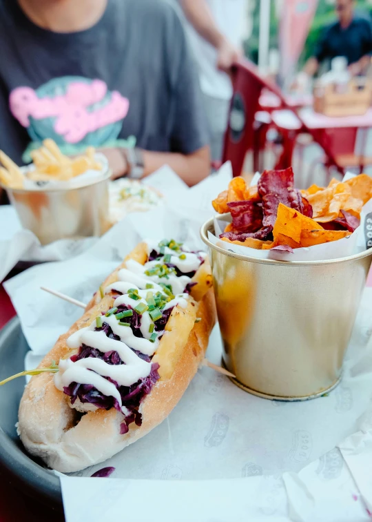 a person sitting at a table with a plate of food, hot dog, maroon and white, rafeal albuquerque, shiny and sparkling