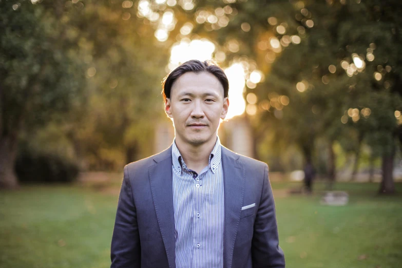 a man in a suit standing in a park, a portrait, unsplash, shin hanga, ismail inceoglu and ruan jia, headshot profile picture, evening light, official photo