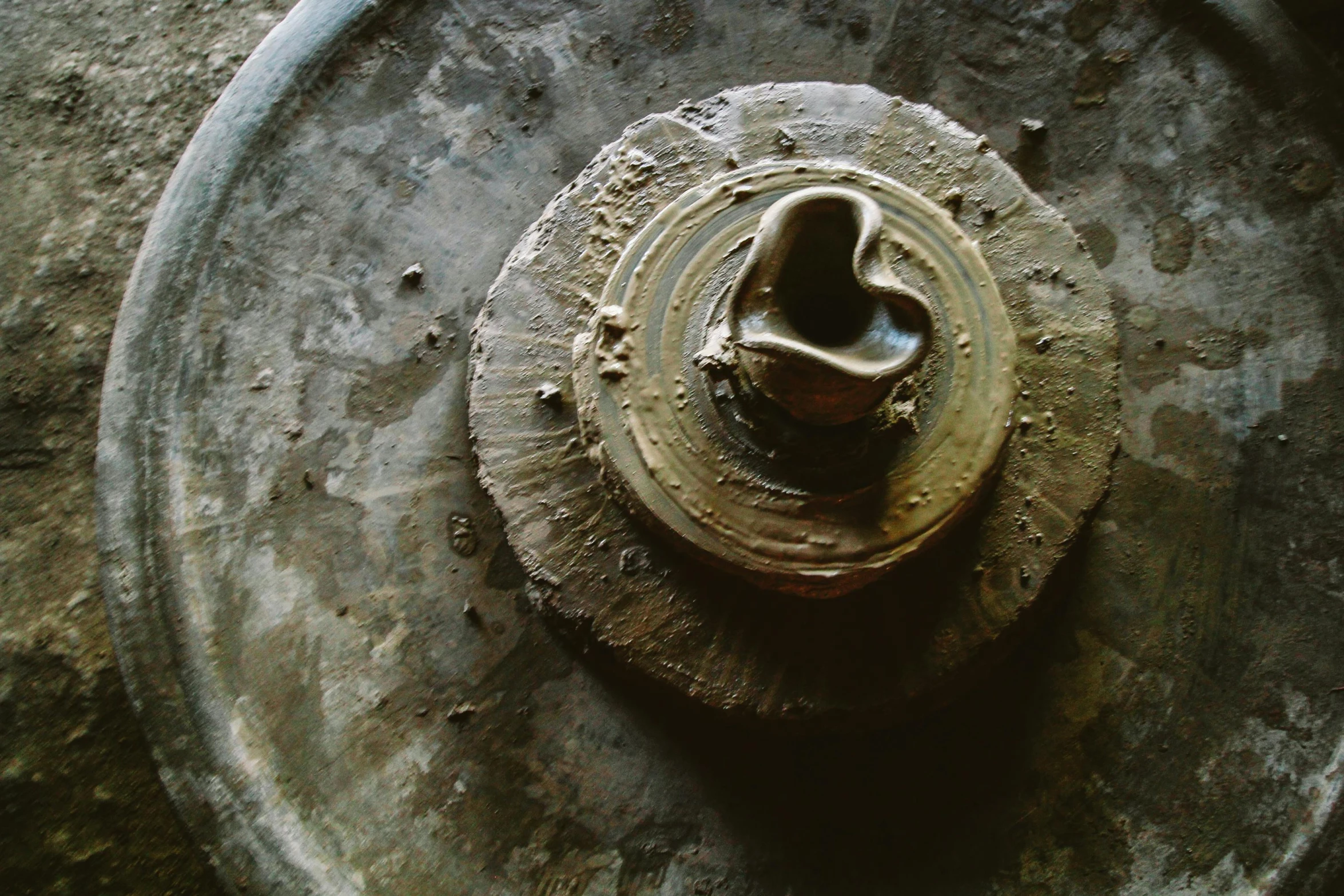 a rusty fire hydrant sitting on top of a cement floor, inspired by Max Ernst, trending on unsplash, assemblage, silver platter, ancient ochre palette, plates, the sacred cup of understading