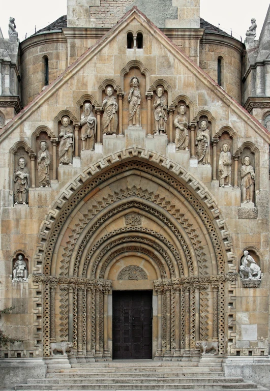 a couple of people that are standing in front of a building, romanesque, massive decorated doors, chrome cathedrals, portal, photograph