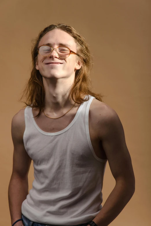 a man standing with his hands in his pockets, an album cover, by Andrew Stevovich, trending on reddit, attractive androgynous humanoid, wearing tank top, long ginger hair, jewish young man with glasses