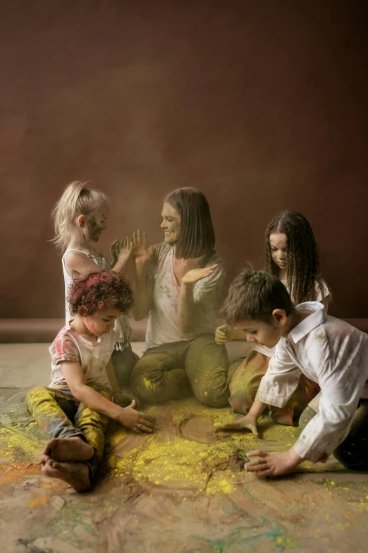 a group of children playing with colored powder, a colorized photo, by Lucia Peka, interactive art, yellow ochre, studio portrait, on canvas, dust light