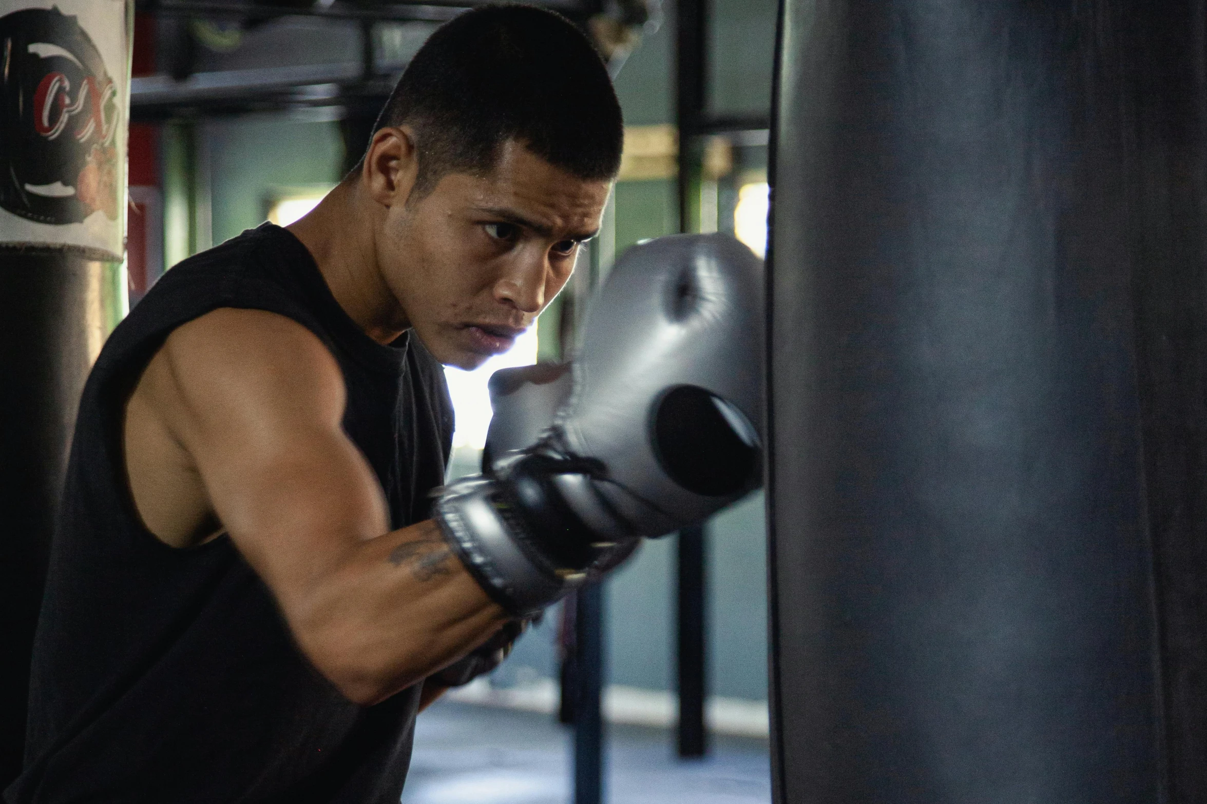 a man standing next to a punching bag, pexels contest winner, realism, working out, background image, david marquez, profile image