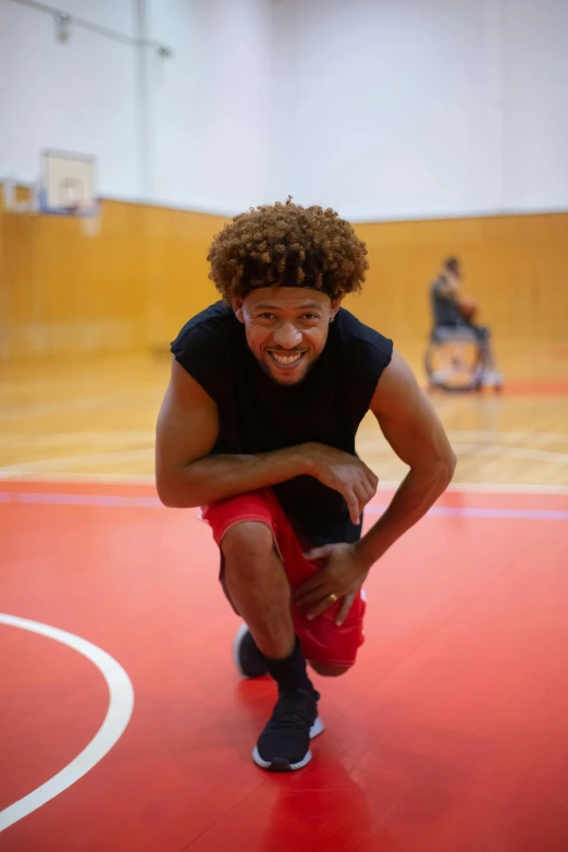 a man squatting down on a basketball court, by Jacob Toorenvliet, curly afro, looking happy, wrestling, profile image
