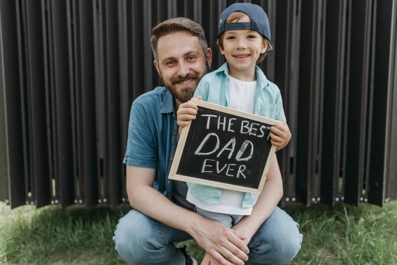 a man holding a sign that says the best dad ever, pexels contest winner, avatar image, instagram post, 15081959 21121991 01012000 4k, lachlan bailey