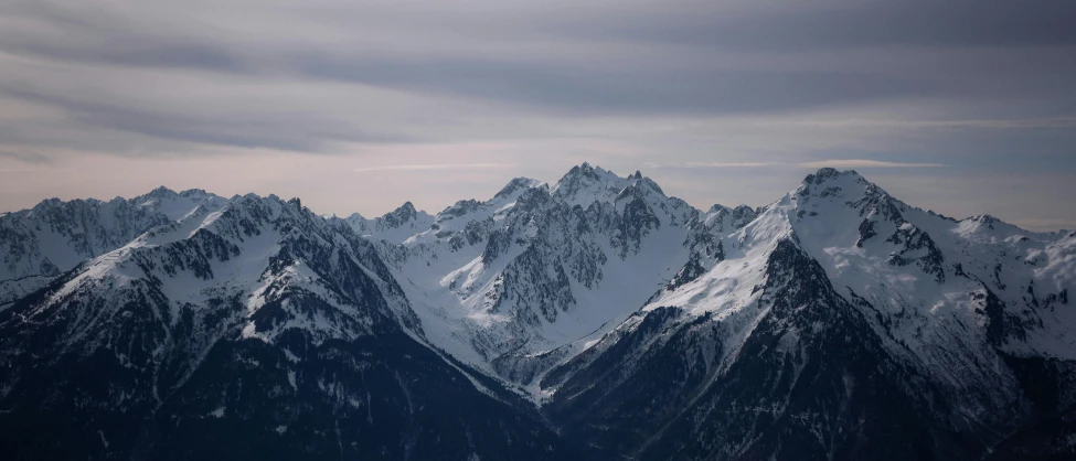 a group of snow covered mountains under a cloudy sky, an album cover, pexels contest winner, 2 0 0 mm telephoto, chamonix, 8 k smooth, high view