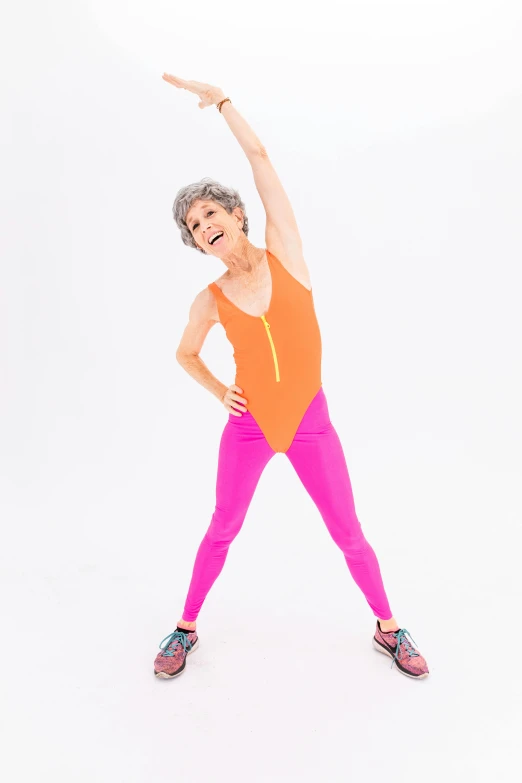 a woman doing a yoga pose against a white background, by Pamela Drew, renaissance, wearing track and field suit, day-glo colors, she is about 7 0 years old, chrome bodysuit