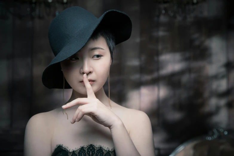 a woman holding her finger to her lips, by Yu Zhiding, pexels contest winner, surrealism, black pointed hat, young cute wan asian face, pale - skinned, vintage color