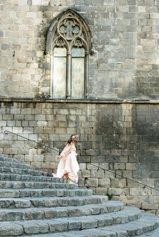a woman in a pink dress walking up some steps, inspired by Modest Urgell, pexels contest winner, romanesque, long dress, castles, movie photo