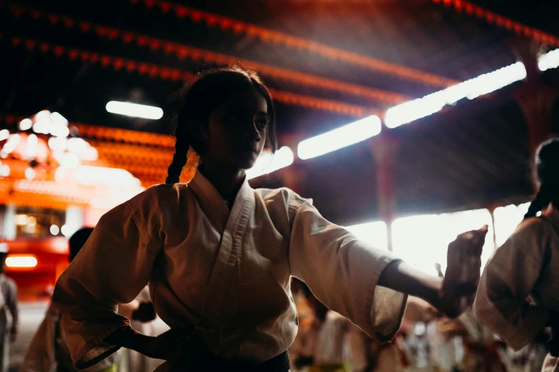 a couple of people standing next to each other, by Lee Loughridge, unsplash contest winner, martial arts tournament, girl under lantern, karate pose, sri lanka