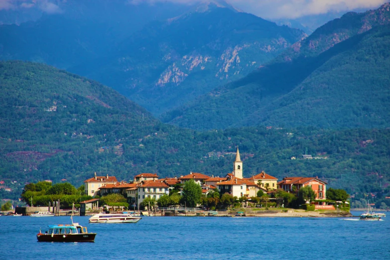 a large body of water with mountains in the background, by Julia Pishtar, pexels contest winner, medieval coastal village, bizzaro, in the style wes anderson, family friendly