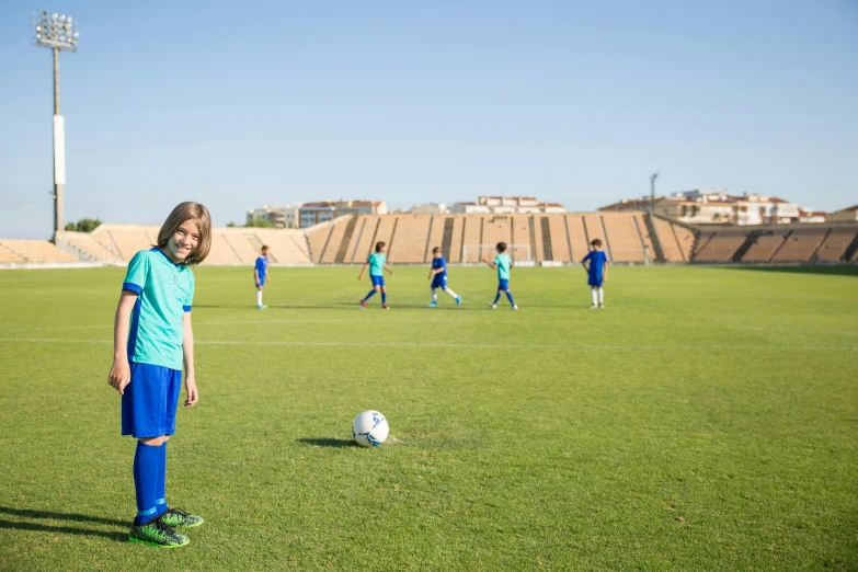 a young girl standing in front of a soccer ball, pexels contest winner, les nabis, in the center midground, costa blanca, a green, university