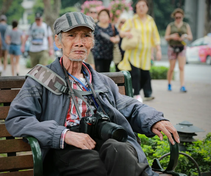 a man sitting on a bench with a camera, by Wen Zhenheng, pexels contest winner, photorealism, portrait of hide the pain harold, paparazzi shot, solo male weary soldier, full frame