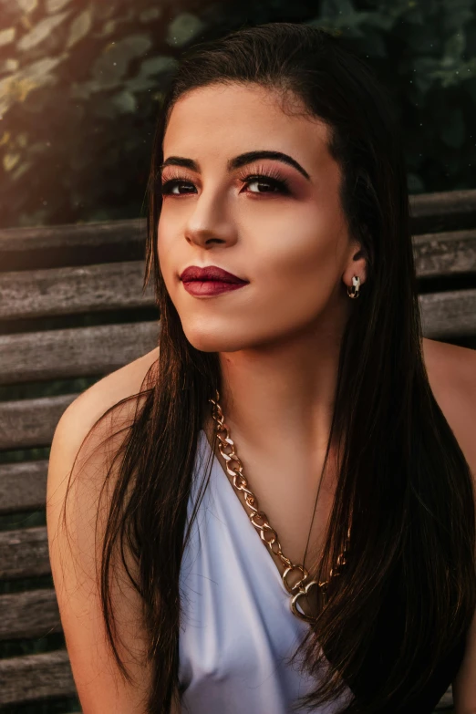 a woman sitting on top of a wooden bench, an album cover, inspired by Elsa Bleda, trending on pexels, renaissance, evening makeup, headshot portrait, wearing a gold chain, violet myers