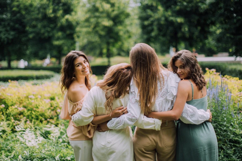 a group of women standing next to each other, by Emma Andijewska, pexels contest winner, happening, sweet hugs, lush surroundings, attractive girl, white clothing