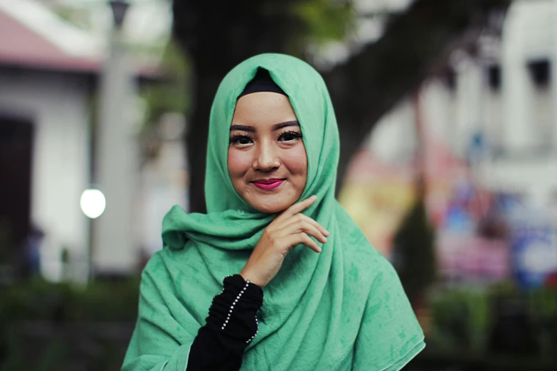 a woman in a green hijab poses for a picture, pexels contest winner, hurufiyya, square, asian human, background, diverse