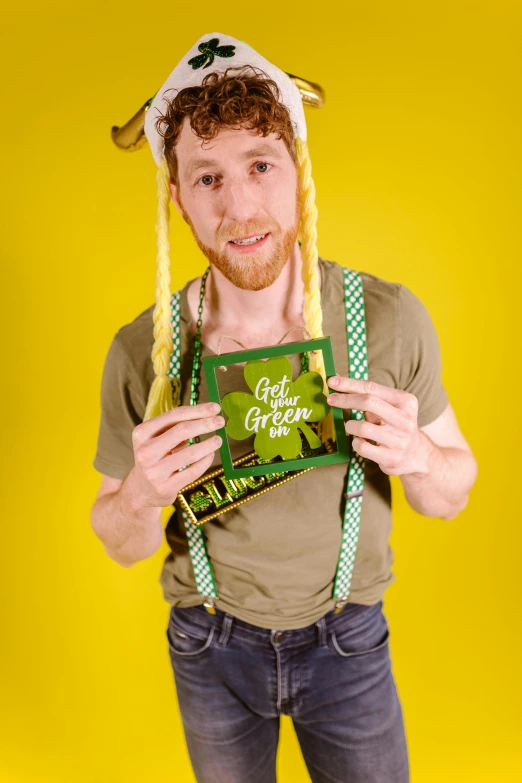 a man in a st patrick's day hat holding a book, an album cover, inspired by Bernd Fasching, goldilocks, studio photoshot, liam, asmongold