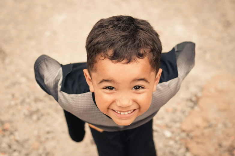 a little boy that is standing in the dirt, pexels contest winner, happening, smiling down from above, centered shoulders up view, 15081959 21121991 01012000 4k, winged boy