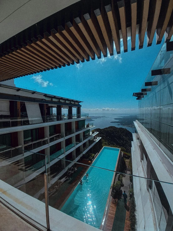 a view of a swimming pool from a balcony, a portrait, unsplash contest winner, panorama view of the sky, sky bridge, resort, glass reflections on top