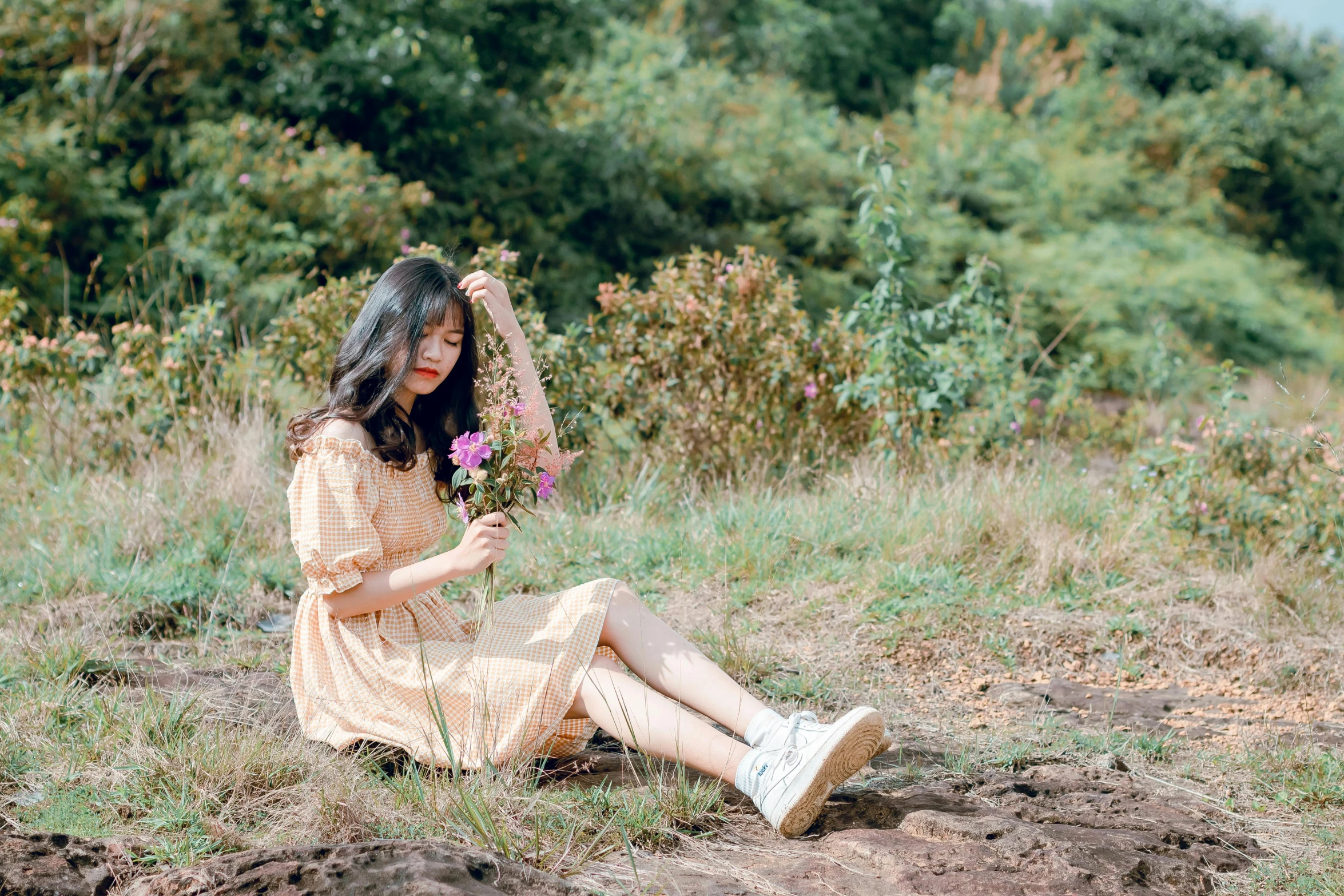 a woman sitting on the ground holding a flower, unsplash, romanticism, ulzzang, wearing in a summer dress, avatar image, wearing off - white style