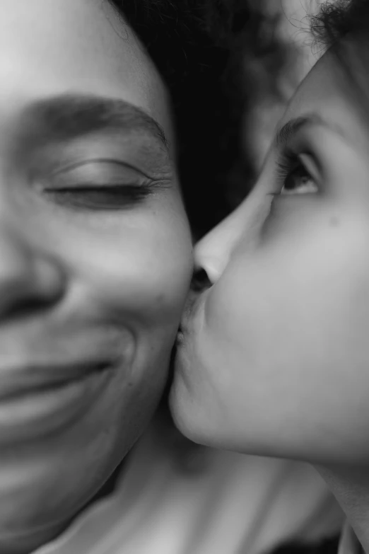 a woman kissing a little girl on the cheek, a black and white photo, by Felix-Kelly, tumblr, photorealism, ashteroth, face!!!! close - up, non-binary, 15081959 21121991 01012000 4k