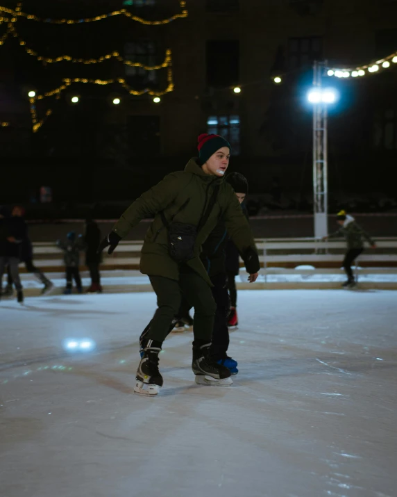 a man riding a skateboard on top of a snow covered ground, during the night, a group of people, non-binary, trending photo
