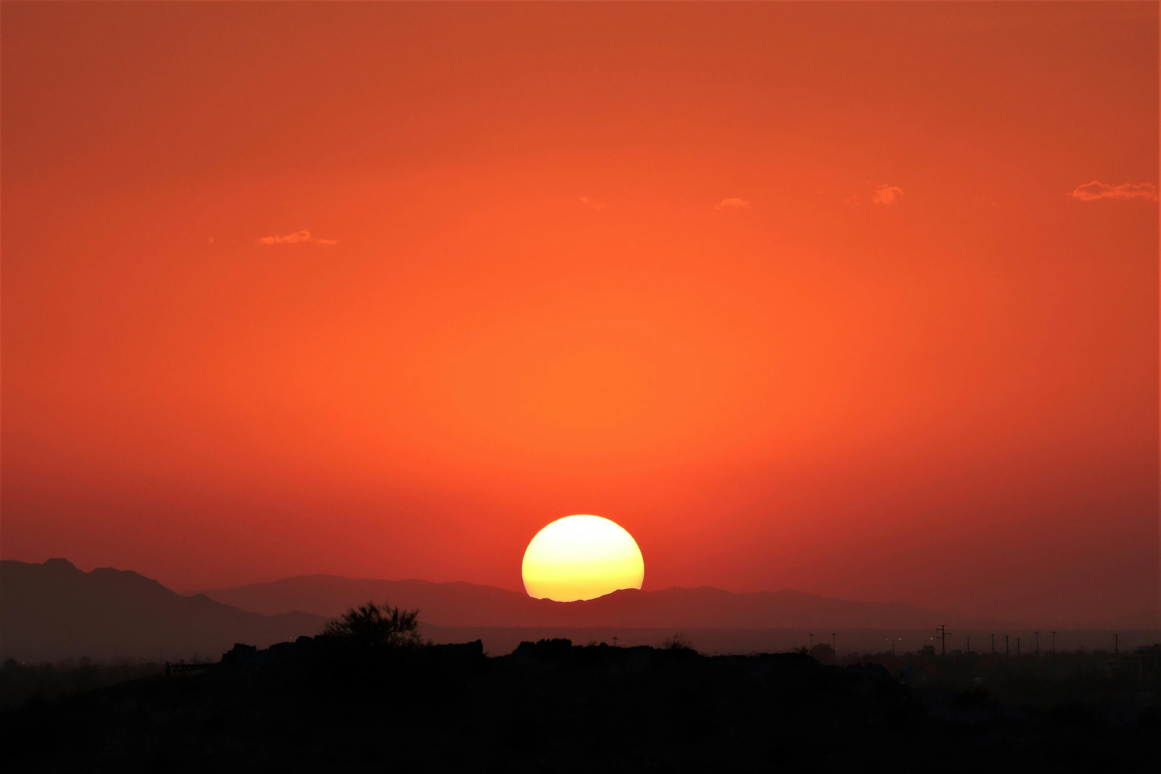 the sun is setting over the mountains in the distance, pexels contest winner, digital yellow red sun, hot and humid, desert setting, afternoon