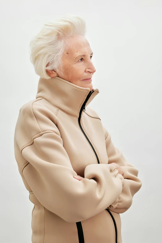 an older woman standing with her arms crossed, inspired by Anna Füssli, beige hoodie, goop, frank gehry, ignant