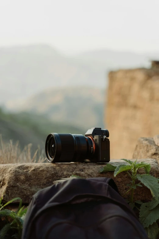 a camera sitting on top of a rock next to a backpack, inspired by Steve McCurry, unsplash contest winner, sony a 7 siii, filmic lut, profile shot, high angle camera