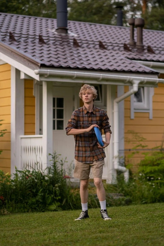 a young man holding a frisbee in front of a house, by Ejnar Nielsen, shutterstock, hyperrealism, midsummer, 8 k movie still, blond boy, wandering