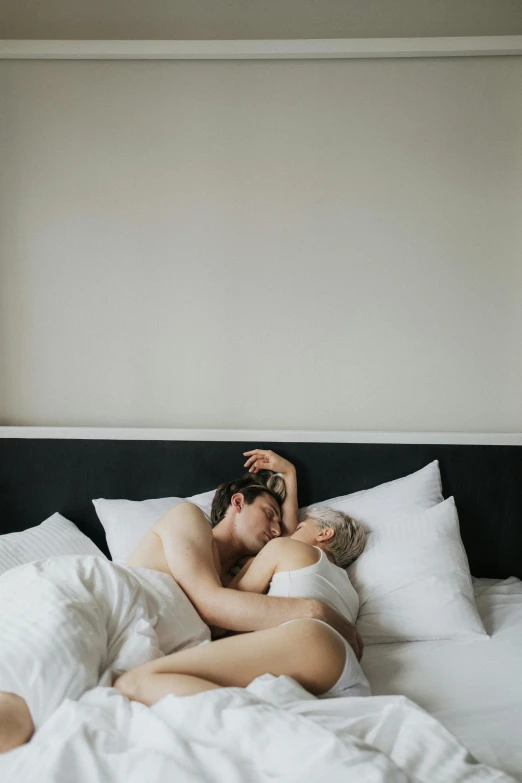 a man laying on top of a bed next to a woman, unsplash, romanticism, non binary model, hugging each other, scandinavian, full-body