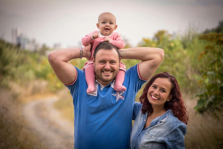 a man holding a baby while standing next to a woman, a portrait, by Dan Luvisi, pixabay contest winner, in the countryside, avatar image, portrait shot 8 k, stacked image