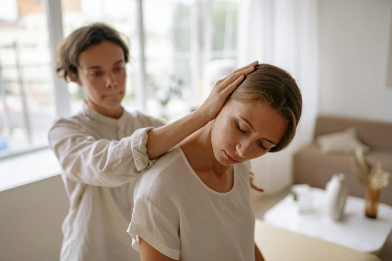 a woman getting her hair done in a salon, by Lee Loughridge, trending on pexels, arm around her neck, morning light showing injuries, bend over posture, manuka