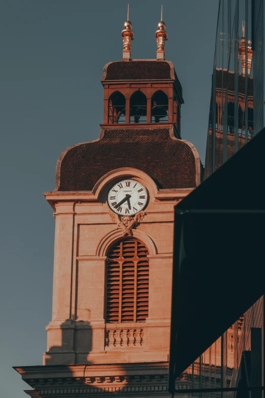 a clock that is on the side of a building, cathedrals, taken at golden hour, black and terracotta, down-town