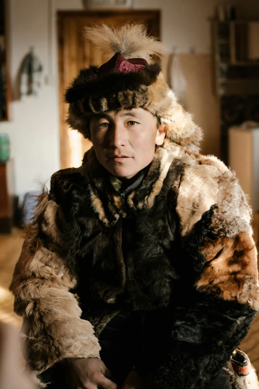 a man in a fur coat sitting on a stool, tengri, looking straight to the camera, one single tribe member, gemma chen