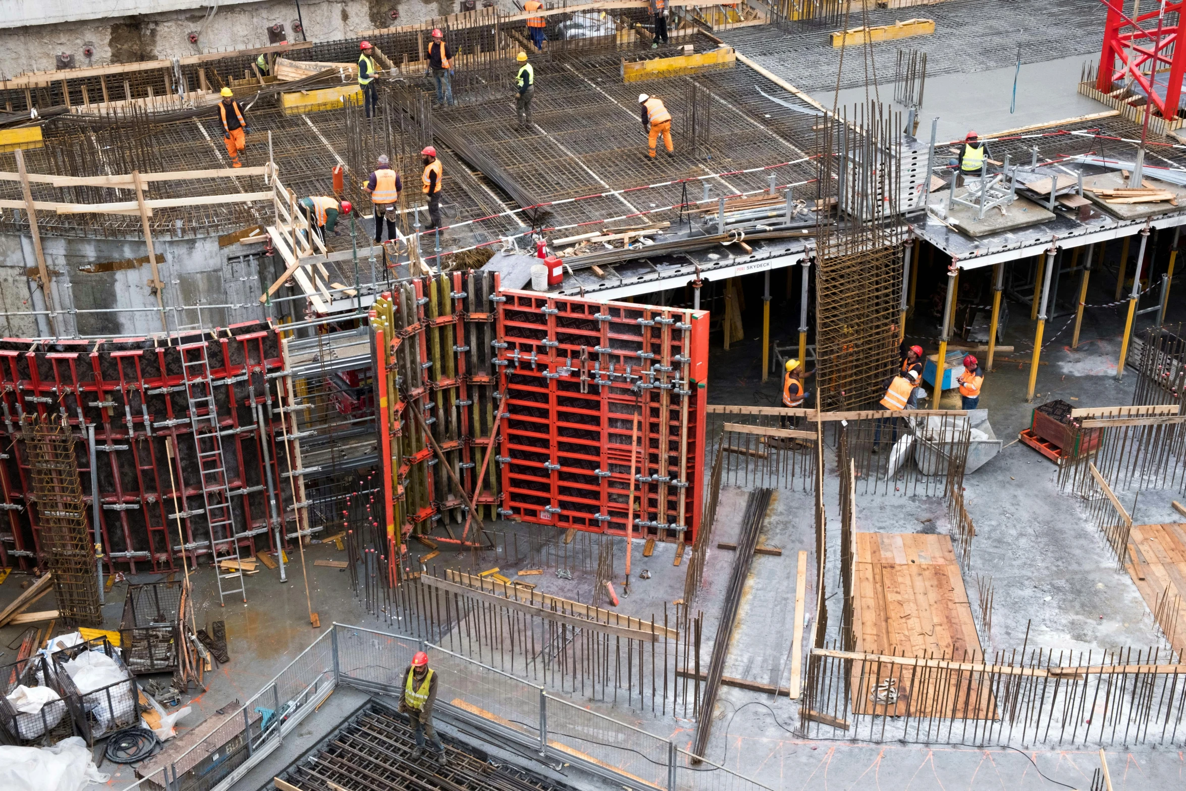 a group of men standing on top of a construction site, by William Berra, pexels contest winner, wet concrete, panels, full colour, high - angle view