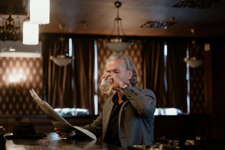 a man sitting at a bar drinking a glass of beer, a portrait, by Jan Tengnagel, pexels, private press, reading a newspaper, henrik fisker, kurt russell, a wide shot