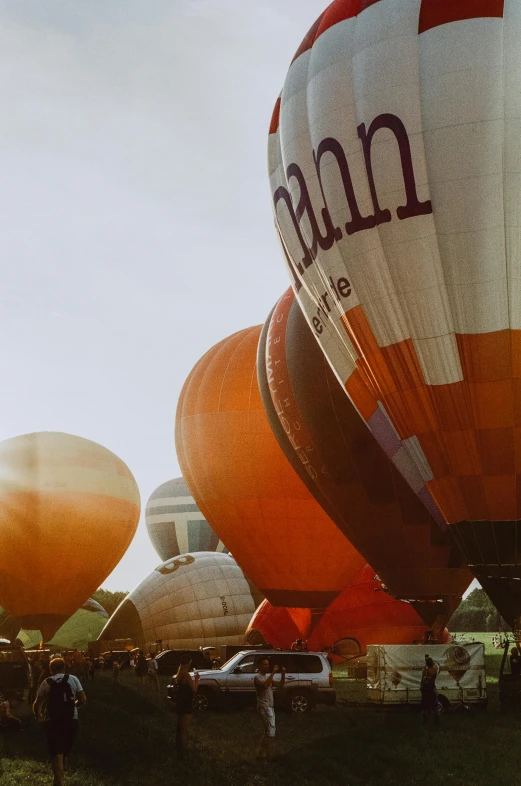 a group of hot air balloons sitting on top of a field, by Jan Tengnagel, happening, grainy quality, some orange and purple, vessels, close-up!!!!!