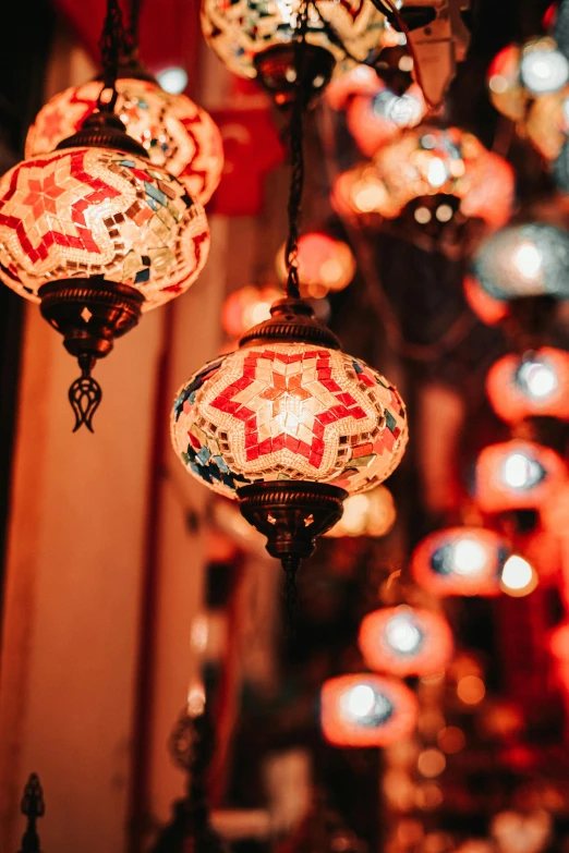 a bunch of lamps hanging from a ceiling, by Julia Pishtar, trending on pexels, arabesque, small red lights, delicious, decorated ornaments, beautifully soft lit