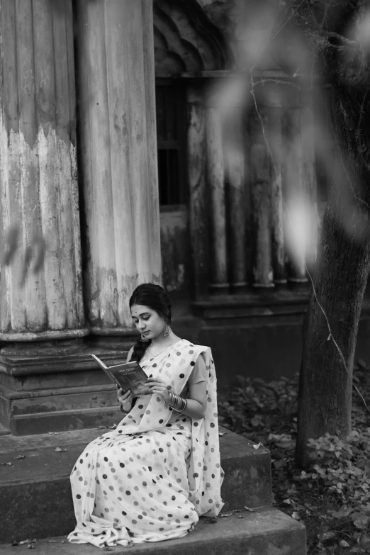 a woman sitting on steps reading a book, a black and white photo, inspired by T. K. Padmini, pexels contest winner, bengal school of art, old movie scene, classical style, sari, autumn