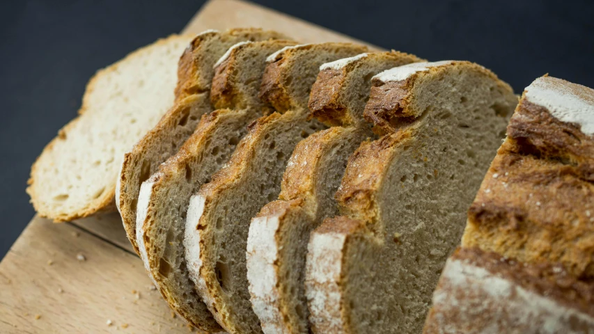 a loaf of bread sitting on top of a wooden cutting board, a portrait, unsplash, sliced bread in slots, detailed product image, round-cropped, bartlomiej gawel