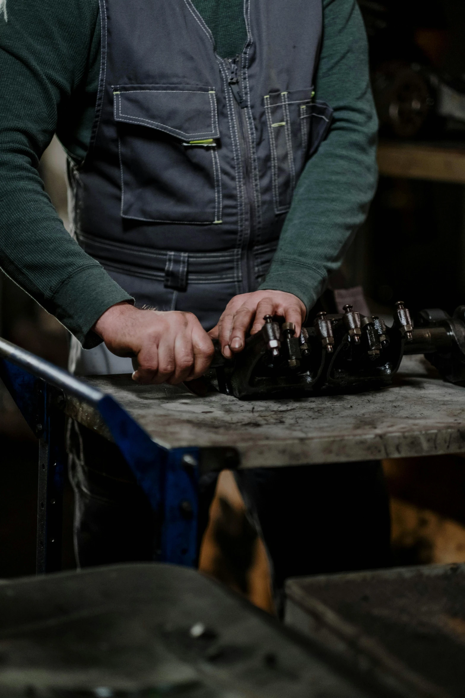 a man that is standing in front of a table, pexels contest winner, arbeitsrat für kunst, holding a wrench, engines, cast iron material, inspect in inventory image